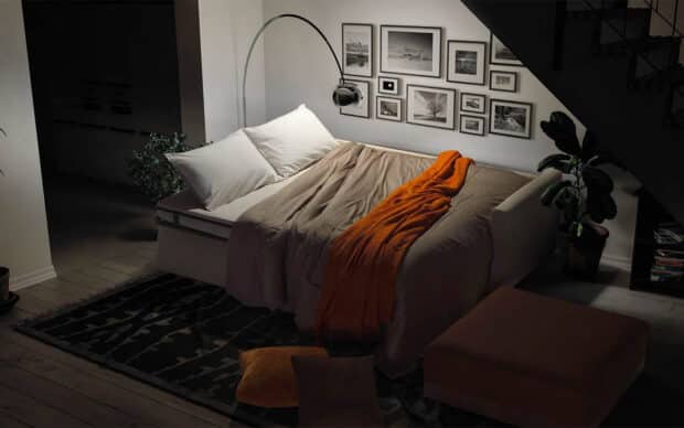 divano letto sfinge minimo ingombro aperto ambientato con pouf e cuscini